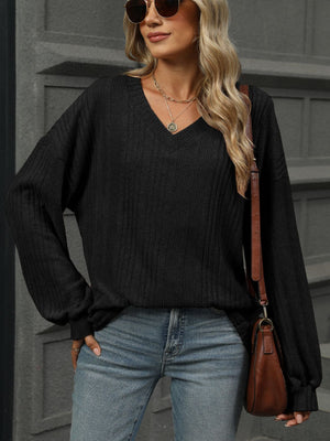 Textured ribbed V-neck top in black with blouson sleeves.