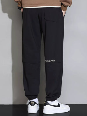 Black cuffed joggers with "TO FIGHTER" detail on the leg.
