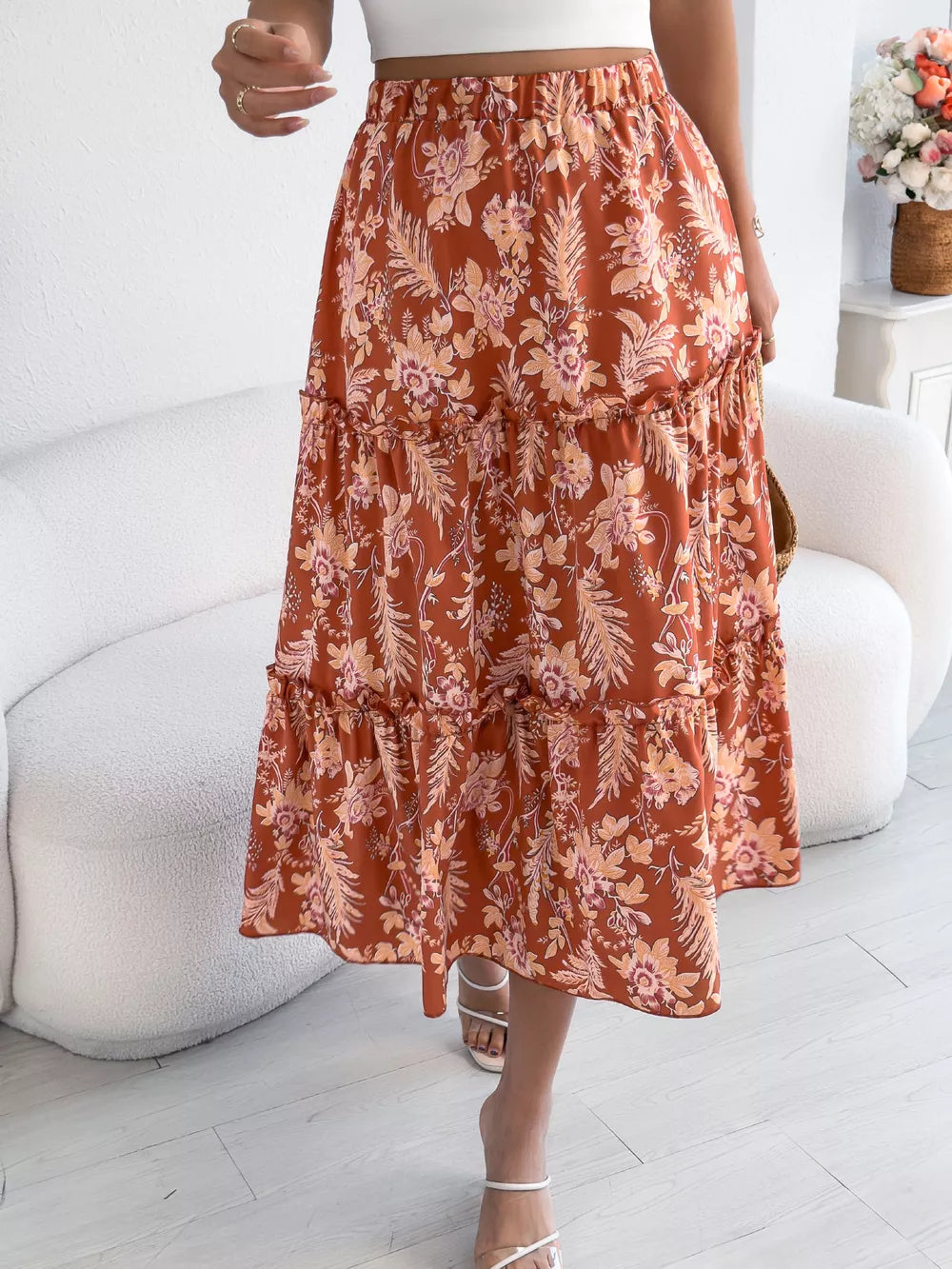 Orange floral midi skirt with tiered ruffles and an elastic waist.