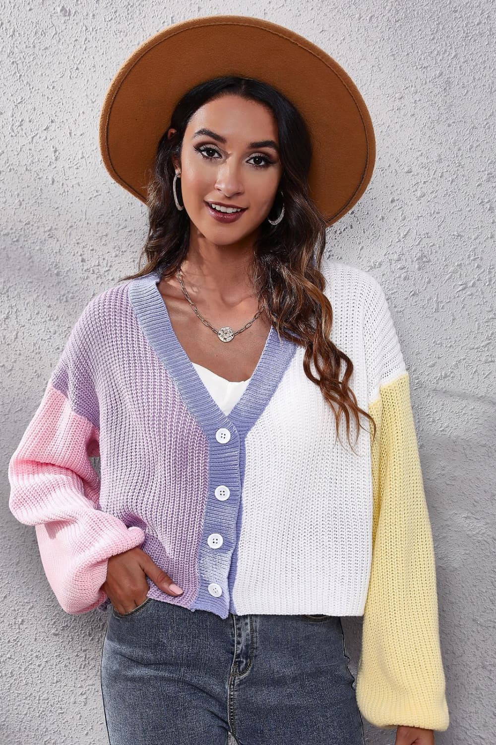 Panelled ribbed knit cardigan with V-neck, button front, and colorblock sleeves in pink, lavender, white, and yellow.