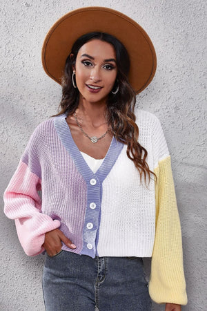 Panelled ribbed knit cardigan with V-neck, button front, and colorblock sleeves in pink, lavender, white, and yellow.