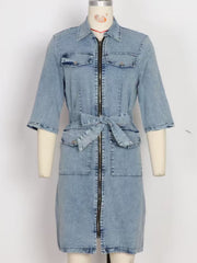 Light blue denim shirt dress with zipper front, tie waist, and chest pockets.