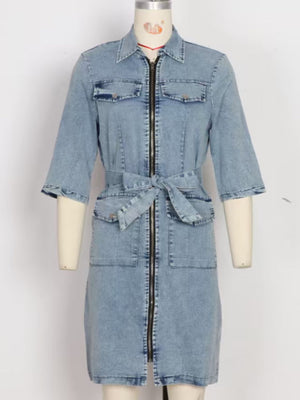 Light blue denim shirt dress with zipper front, tie waist, and chest pockets.