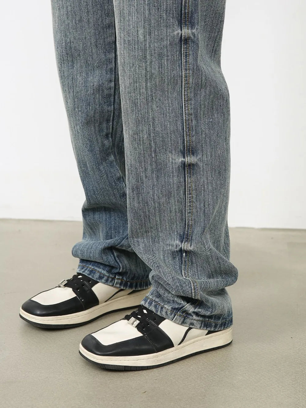 Vintage wash wide-leg denim jeans in dusty blue, styled with sneakers.