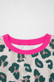 Pajama top with leopard print and bright pink crew neck trim.