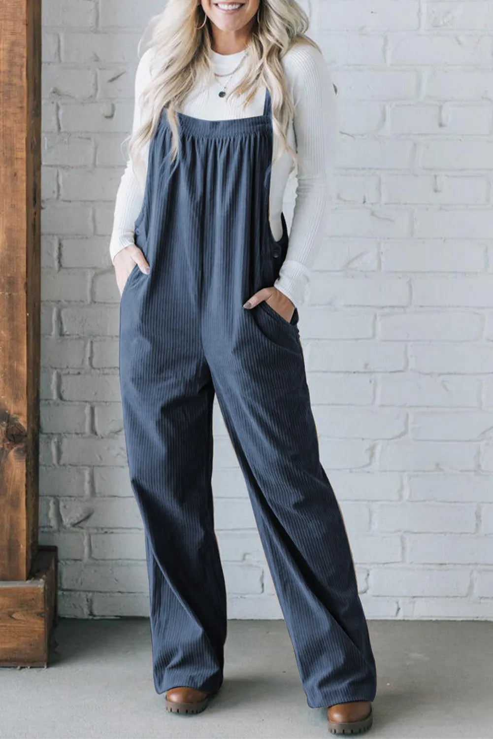 Peacock blue corduroy wide-leg overalls with front pockets and button detail.
