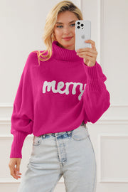 Pink acrylic turtleneck sweater with white "merry" graphic and dolman sleeves.