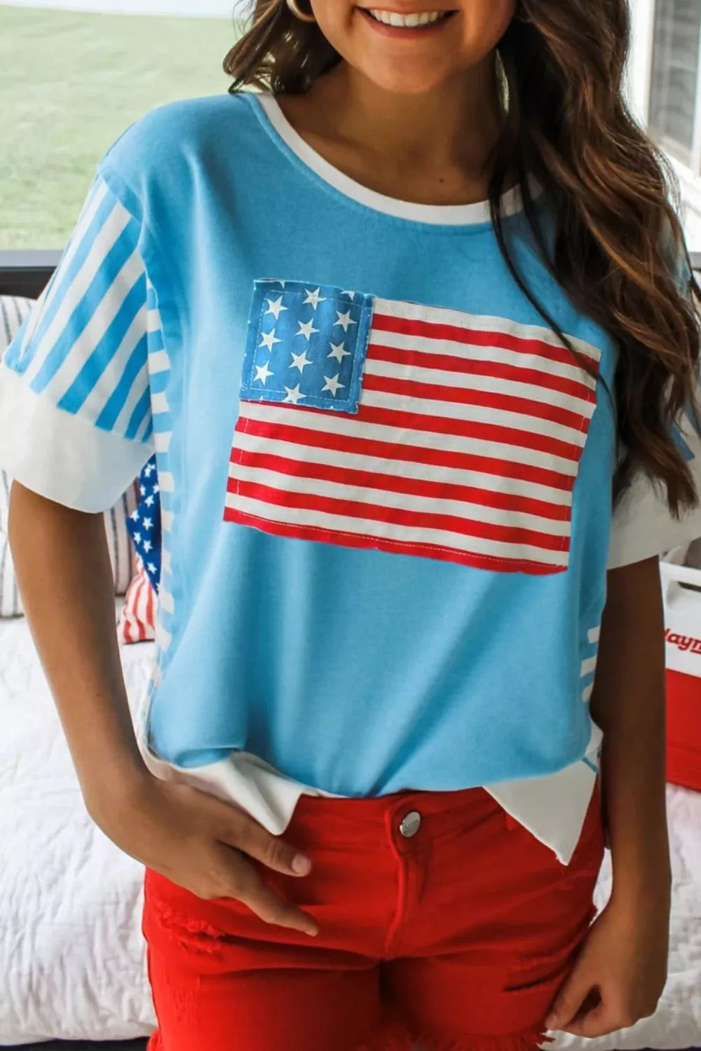 Patriotic patchwork t-shirt with American flag pocket and striped sleeves.