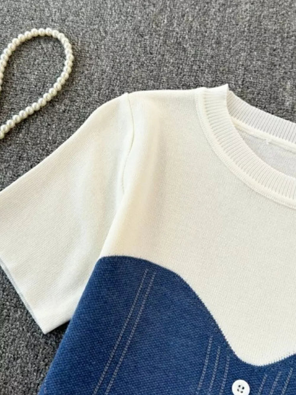 Color block knit t-shirt in white with blue, featuring ribbed detail and a button.