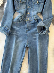 Chic buttoned denim jumpsuit with pockets and cuffed sleeves.