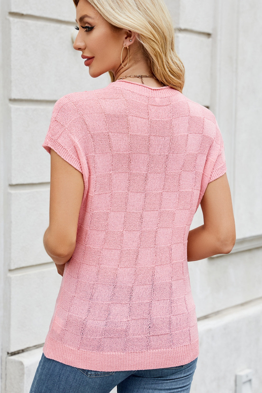 Blush pink knit top with short sleeves and a textured checkered pattern.