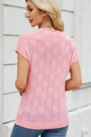Blush pink knit top with short sleeves and a textured checkered pattern.