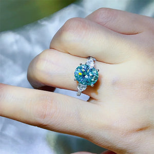 Turquoise moissanite trilogy ring in 925 sterling silver with pear side stones.