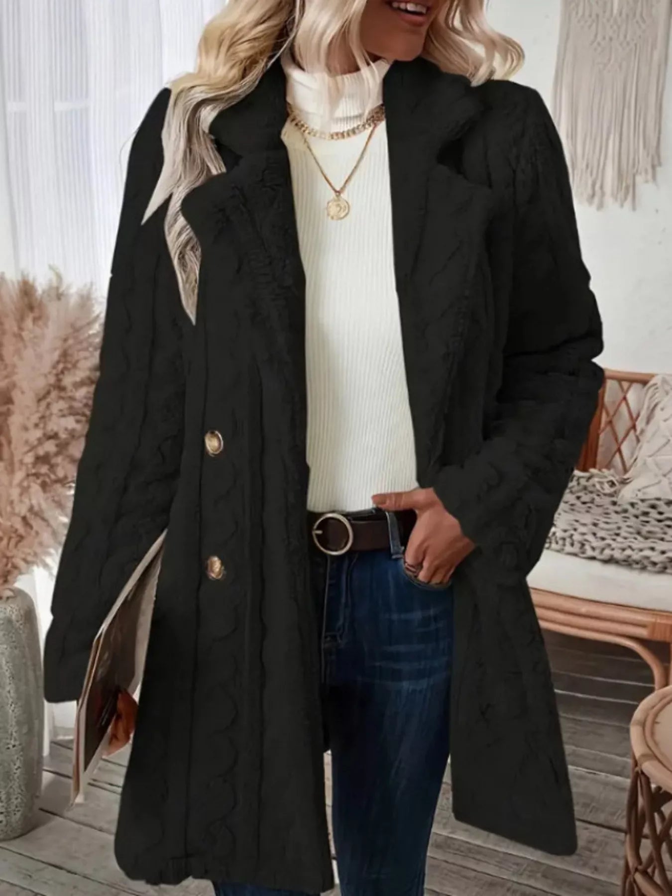 Black faux shearling double-breasted overcoat with cable knit texture and gold buttons.
