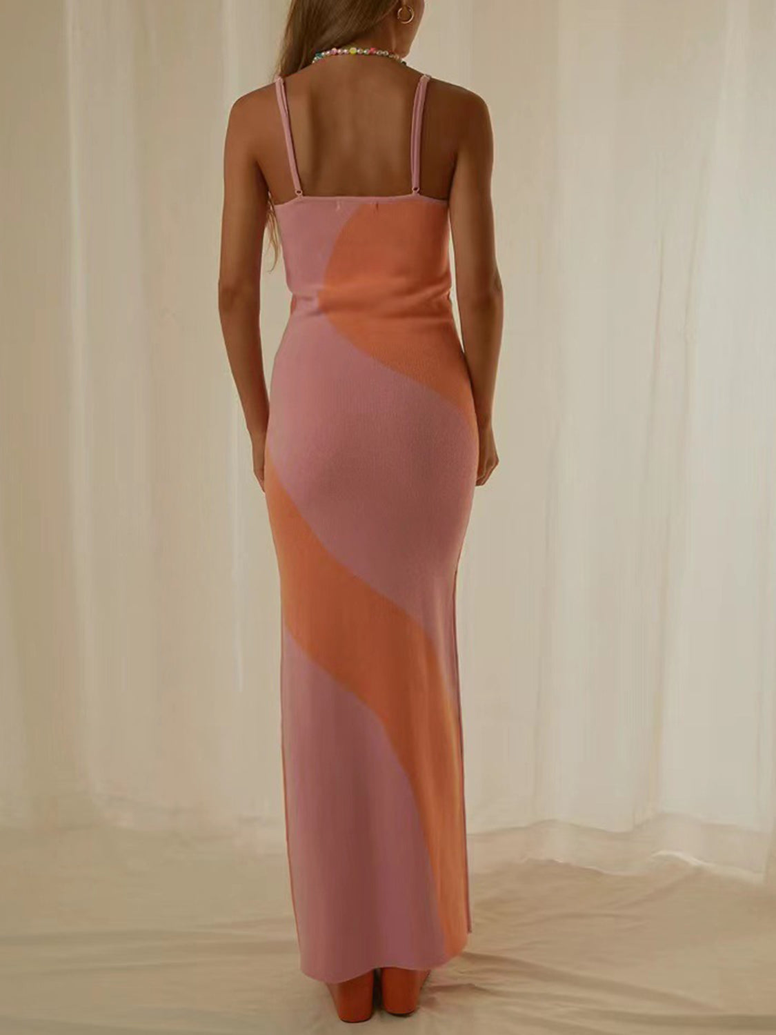 Geometric knit maxi slip dress in pink and orange with diagonal color blocking.