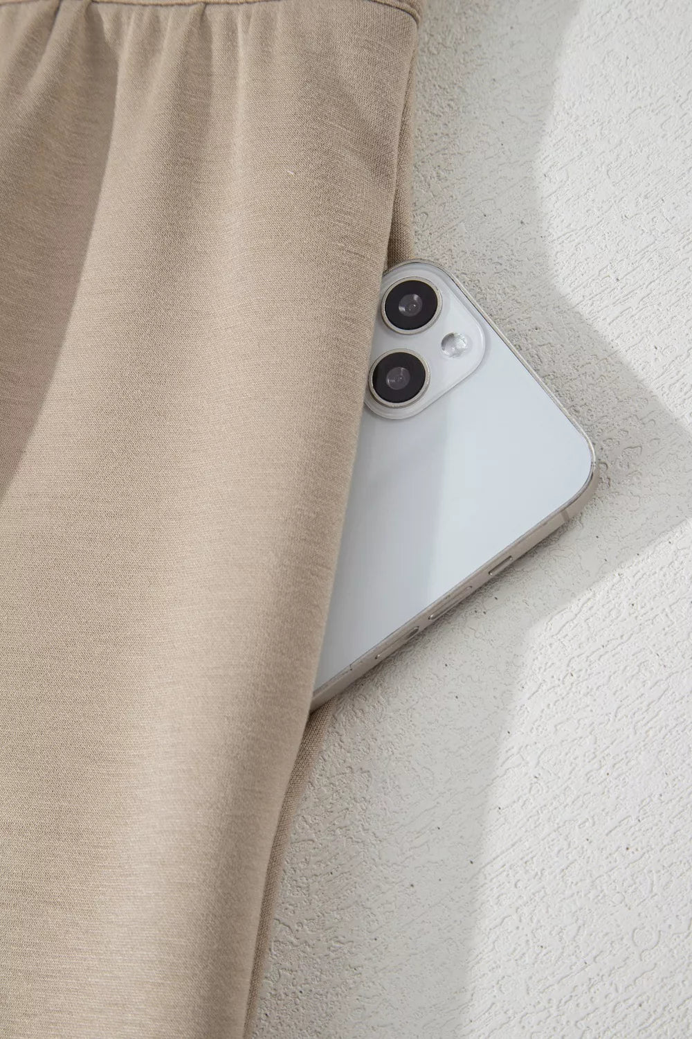 Chic collared romper in beige with a functional pocket holding a phone.