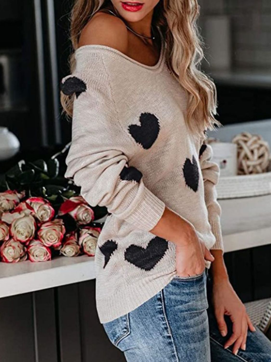 Eggshell heart motif raglan knit sweater with a relaxed fit and off-the-shoulder styling.