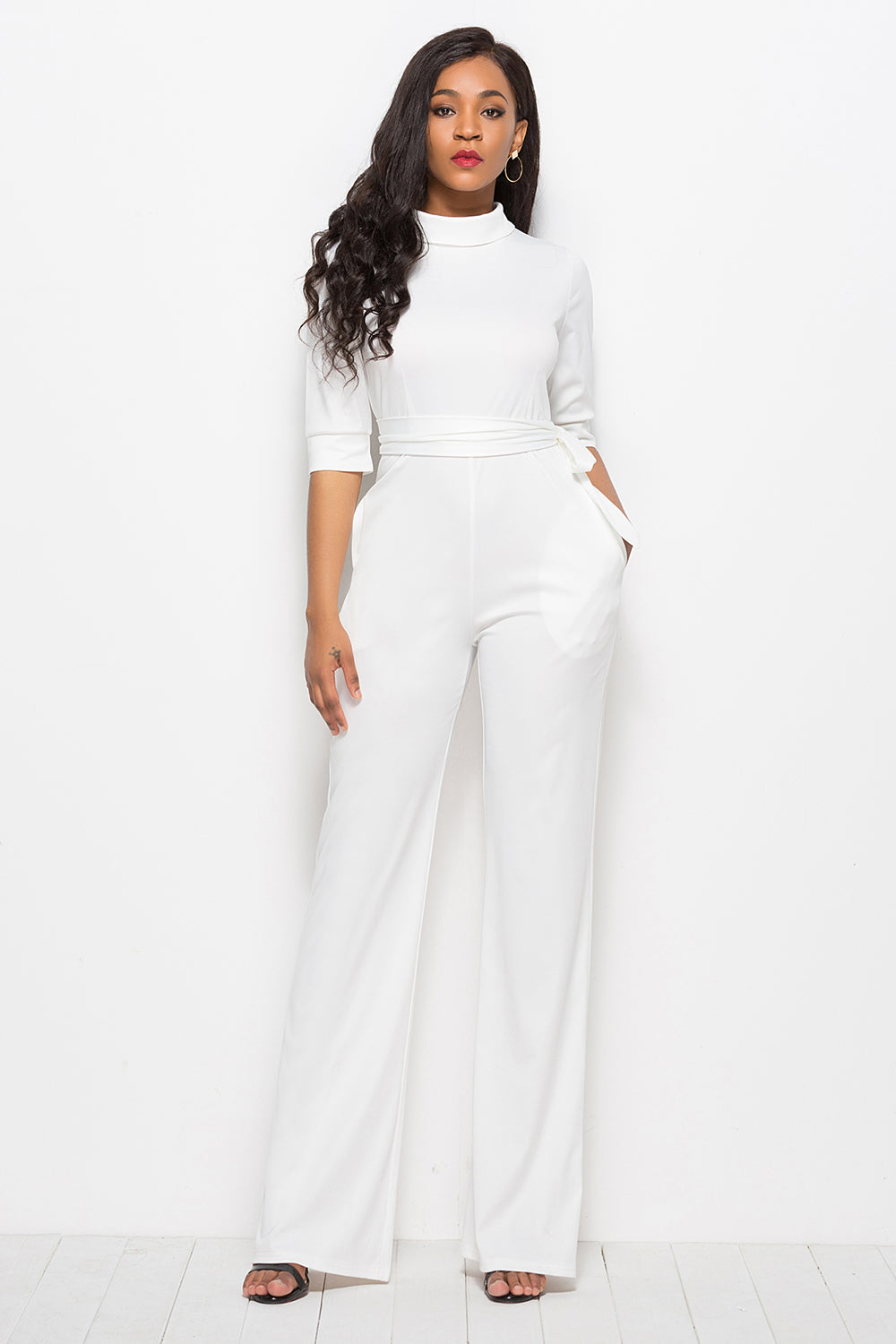 White high-neck belted palazzo jumpsuit with 3/4 sleeves and wide legs.