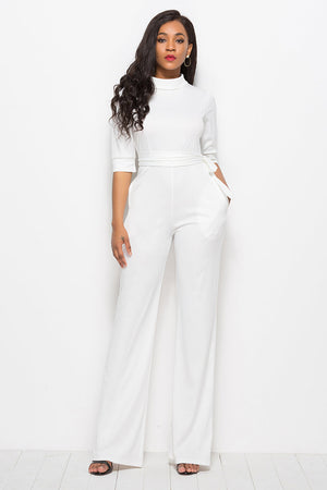 White high-neck belted palazzo jumpsuit with 3/4 sleeves and wide legs.