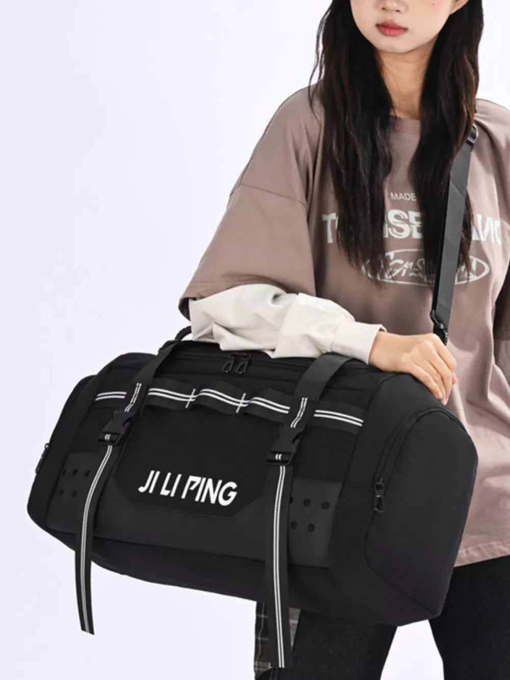 Spacious black Oxford cloth travel tote bag with white stripe details and side pockets.