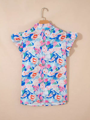 Vibrant floral cotton blouse with tie neck and ruffle sleeves.
