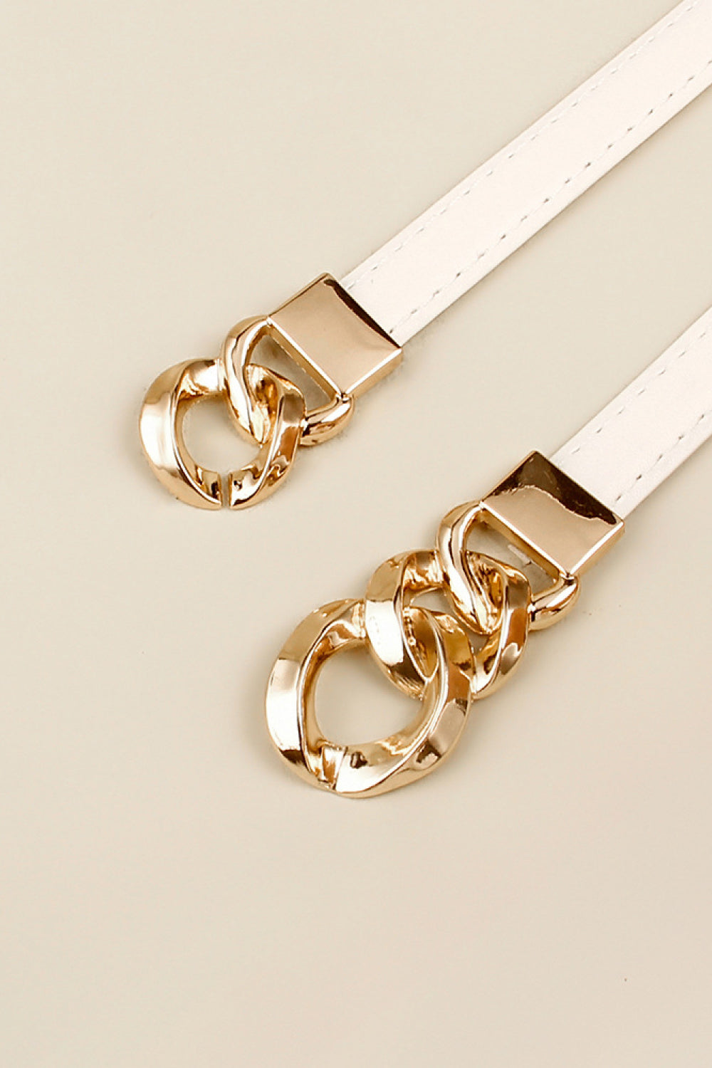White belt with gold chain link buckle detail