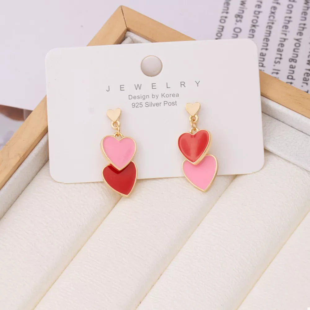 Charming double heart enamel earrings in pink and red with gold posts.