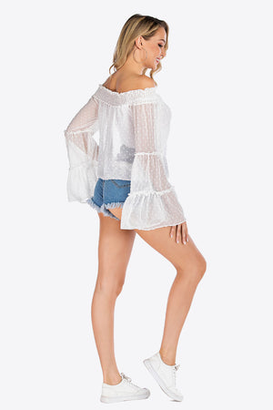 White dotted swiss off-shoulder blouse with ruffle bell sleeves and smocked neckline.