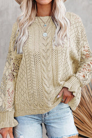 Beige openwork knit sweater with lace sleeves and cable knit detail.