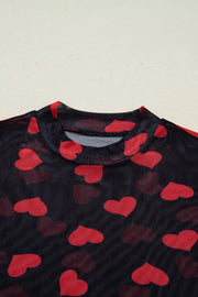 Black sheer mesh top with red heart print and mock neckline.