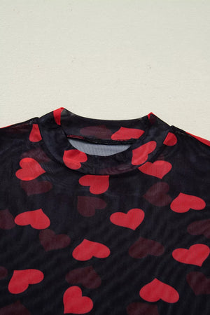 Black sheer mesh top with red heart print and mock neckline.