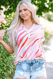 Prismatic stripe henley blouse in blush pink with a v-neck and short sleeves, styled with denim shorts.