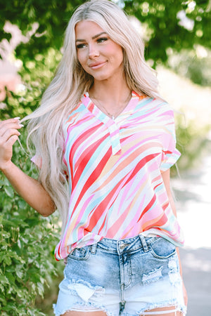 Prismatic stripe henley blouse in blush pink with a v-neck and short sleeves, styled with denim shorts.