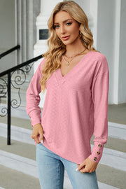 Blush pink diamond-textured V-neck blouse with button cuff detail