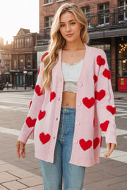 Pink acrylic knit cardigan with red heart appliqués, button front, and ribbed cuffs.