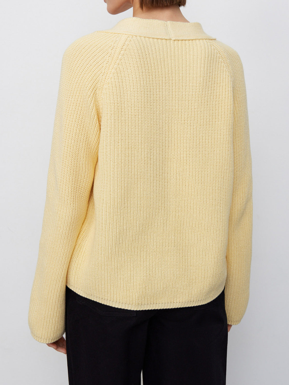 Yellow ribbed raglan cardigan with deep V-neck and button details.