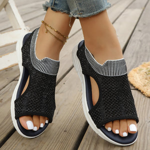 Black open-toe sandals with ankle cuff and white striped trim, breathable knit upper.