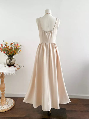 Elegant beige square neck A-line maxi dress with gathered waist and flowing skirt.