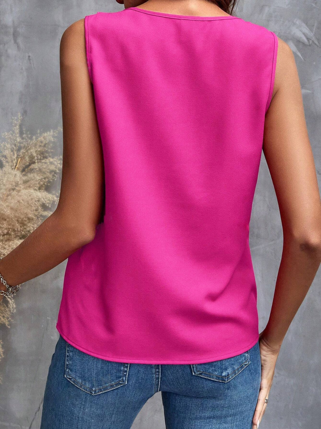 Hot Pink sleeveless blouse with a round neckline, styled with blue jeans.