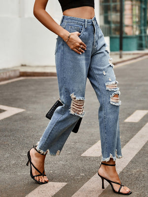 Ripped knee denim jeans in medium wash with raw hem straight leg cut and distressed details.
