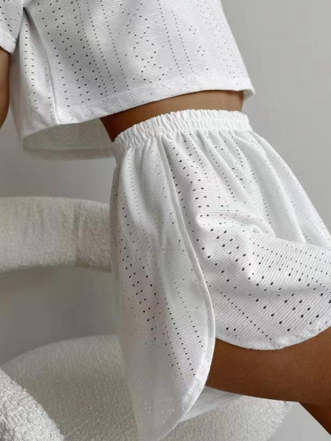 White perforated crop top and shorts set with elastic waistband.