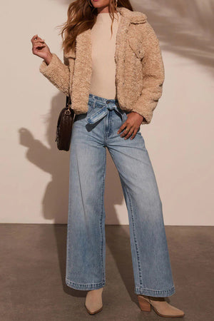 Belted wide-leg denim trousers in medium wash, tied at the waist.