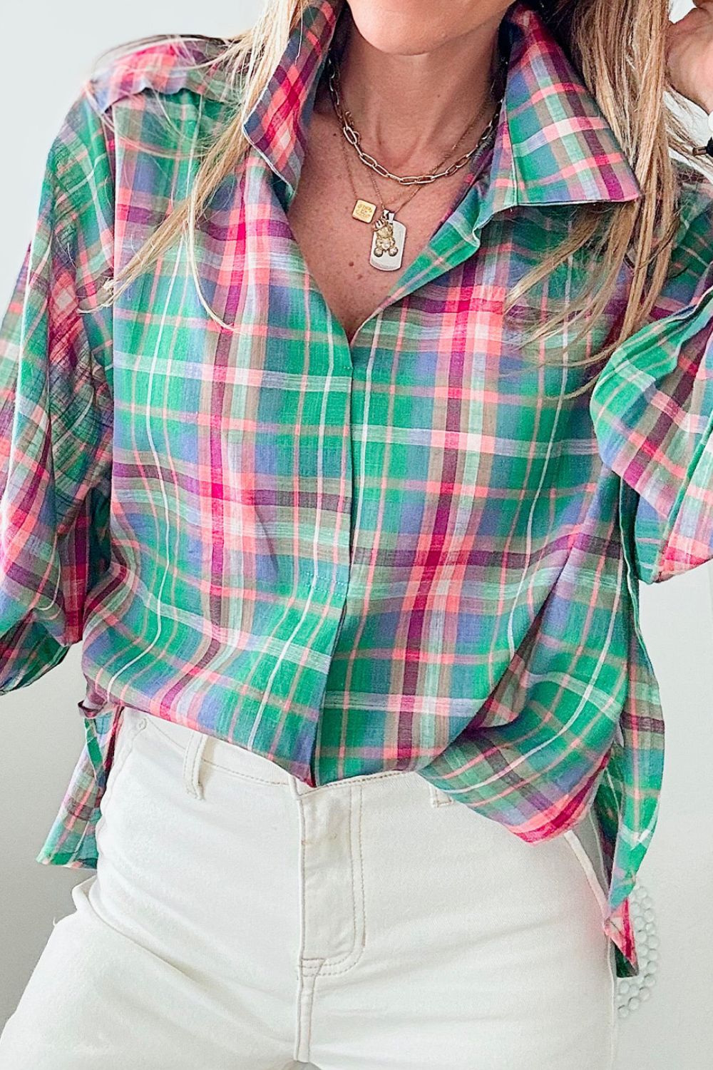 Voluminous plaid blouse with gathered sleeves in green, pink, and purple plaid.