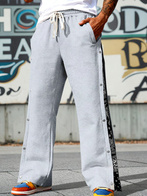 Light gray wide leg sweatpants with side snaps and bandana print trim.