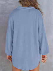 Blue waffle-knit henley tee with buttoned collar and long sleeves.