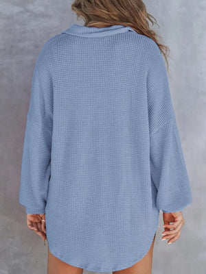 Blue waffle-knit henley tee with buttoned collar and long sleeves.