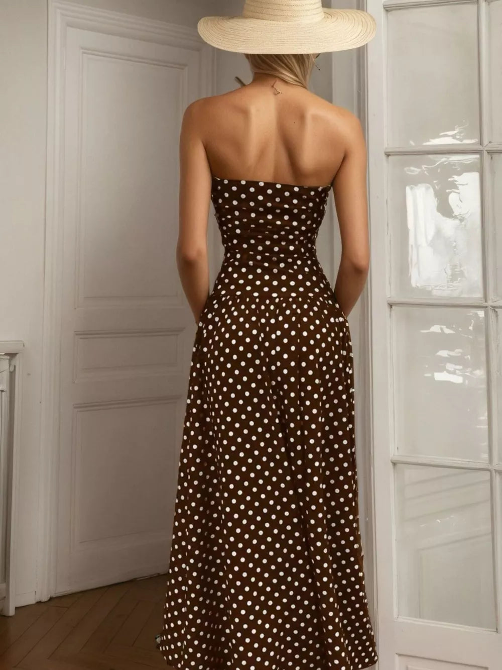 Brown polka dot strapless maxi dress with a flowing skirt.