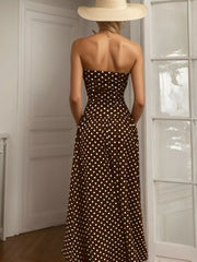 Brown polka dot strapless maxi dress with a flowing skirt.