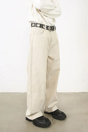 Oversized beige denim jeans with a sculpted leg and neutral wash.