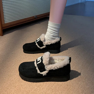 Black shearling loafers with white logo strap detail and cozy lining.